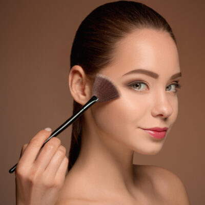 Beauty Girl with Makeup Brush. Bright Make-up for Brunette Woman with Beautiful Face. Perfect Skin. Applying Makeup